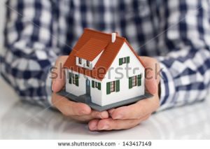 stock-photo-hand-over-mini-house-with-depth-of-field-143417149