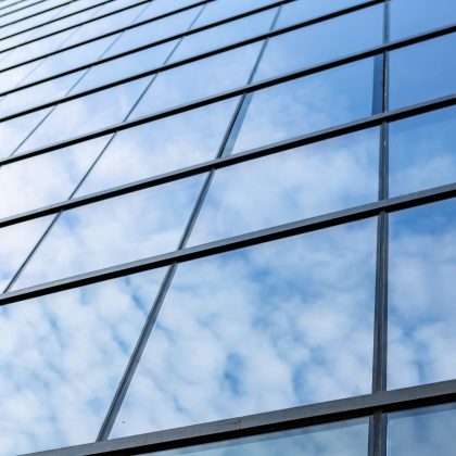 Glass skyscraper against blue sky, view from the bottom